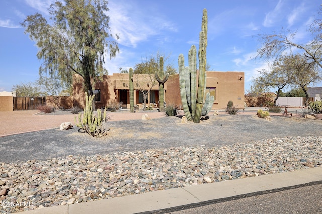 southwest-style home with fence and stucco siding