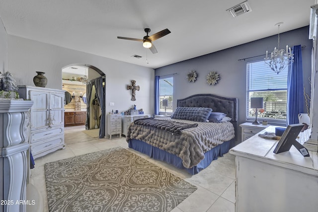 bedroom with arched walkways, multiple windows, light tile patterned flooring, and visible vents