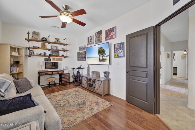 living area featuring ceiling fan, visible vents, light wood-style flooring, and baseboards