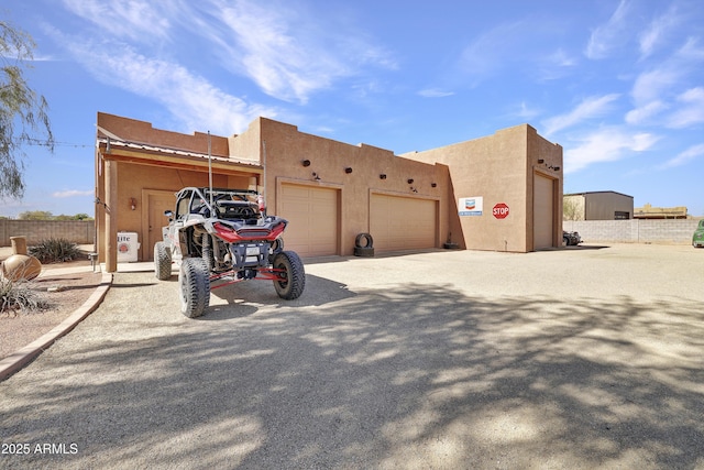 exterior space with fence, driveway, and stucco siding