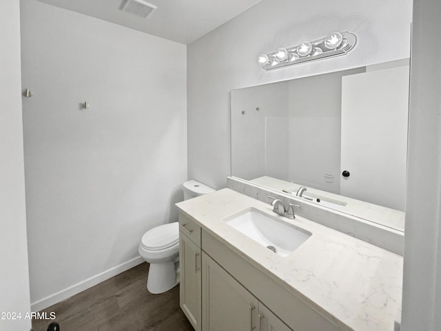 bathroom with hardwood / wood-style floors, vanity, and toilet