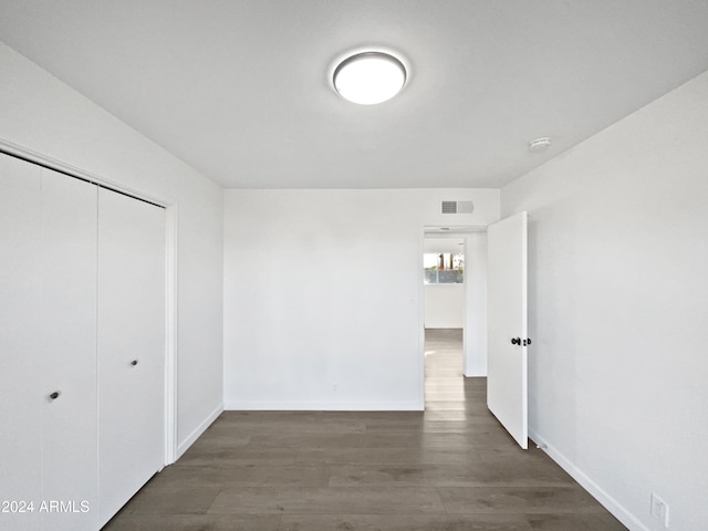 unfurnished bedroom featuring a closet and dark hardwood / wood-style floors