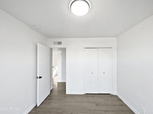 unfurnished bedroom featuring a closet and wood-type flooring