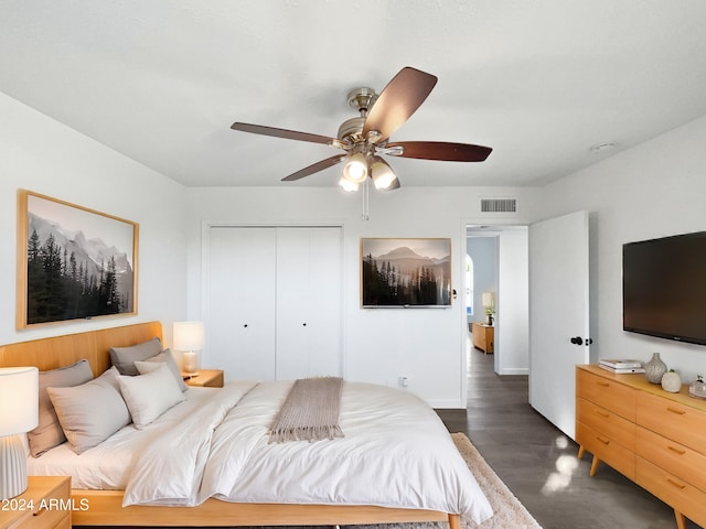 bedroom featuring ceiling fan, dark hardwood / wood-style floors, and a closet