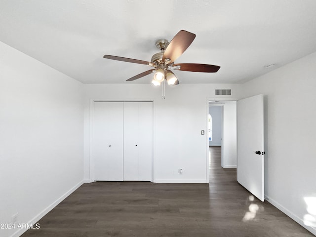 unfurnished bedroom featuring ceiling fan, dark hardwood / wood-style floors, and a closet