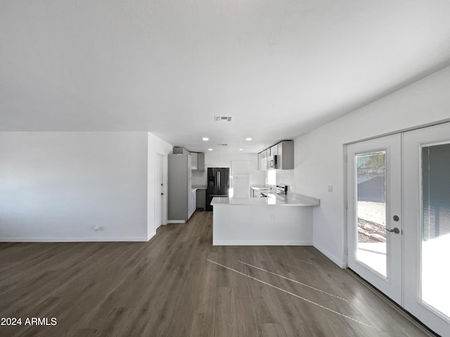 kitchen featuring black refrigerator, kitchen peninsula, french doors, and dark hardwood / wood-style floors