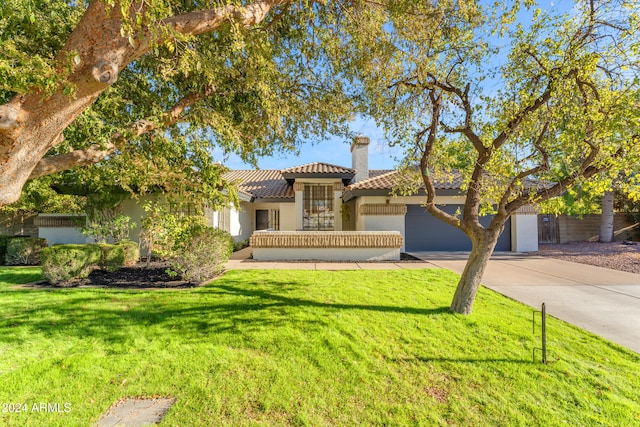 view of front of property featuring a garage and a front lawn