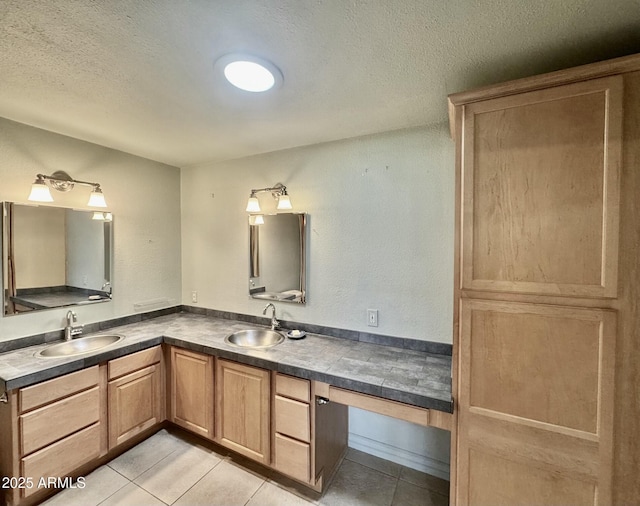 full bathroom with a sink, a textured ceiling, double vanity, and tile patterned flooring