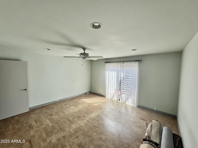 unfurnished room with a textured ceiling, baseboards, and ceiling fan