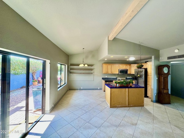 kitchen with a kitchen island, light tile patterned flooring, stainless steel appliances, dark countertops, and beamed ceiling