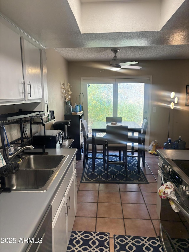 8653 S 51st St Unit 2, Phoenix, AZ 85044 - kitchen featuring a sink, white cabinetry, range, ceiling fan, and a textured ceiling