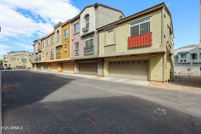 view of front of house featuring a garage, a residential view, and stucco siding