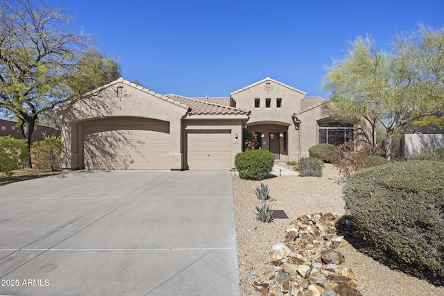 mediterranean / spanish-style home with a garage, concrete driveway, a tile roof, and stucco siding