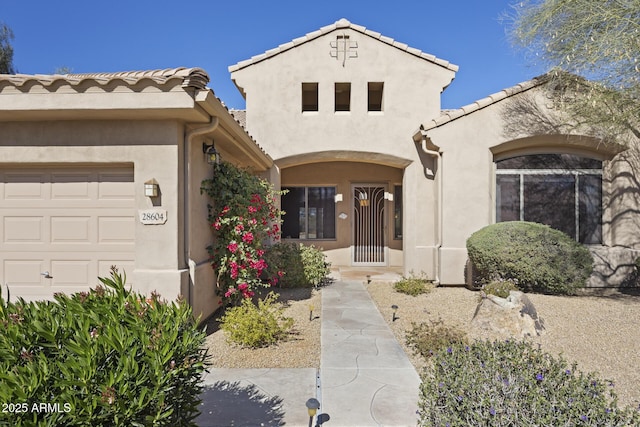 view of front facade featuring a garage, a tile roof, and stucco siding