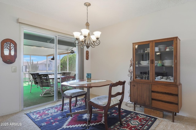 carpeted dining room with a textured ceiling and a chandelier