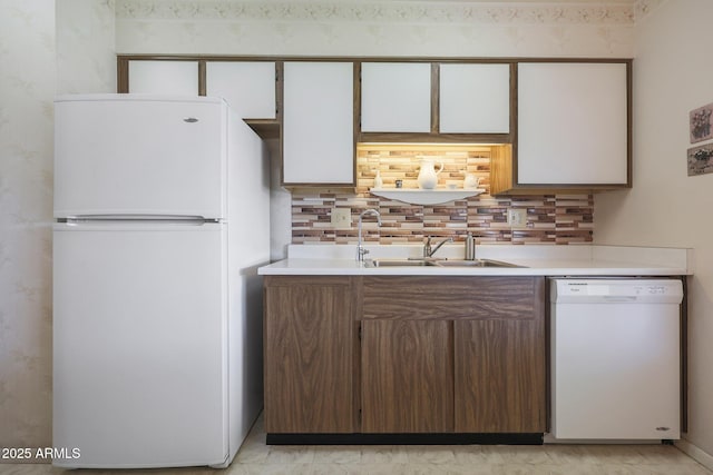 kitchen featuring tasteful backsplash, white cabinetry, sink, and white appliances