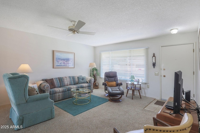 carpeted living room with ceiling fan and a textured ceiling