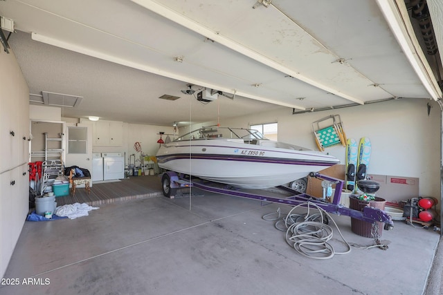 garage with washing machine and clothes dryer and a garage door opener