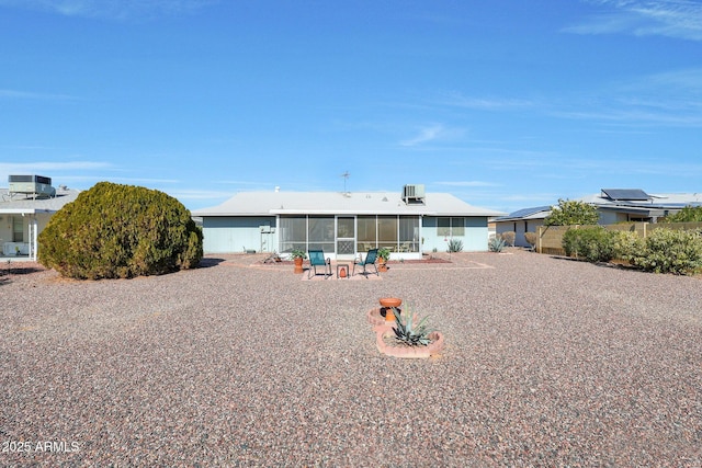 rear view of property with a sunroom and a patio area