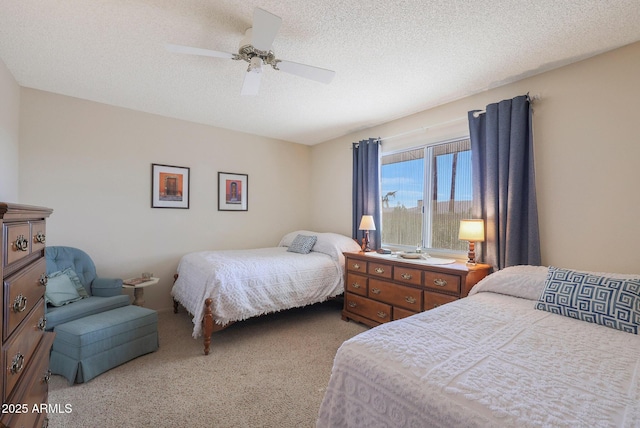 bedroom featuring ceiling fan, light colored carpet, and a textured ceiling