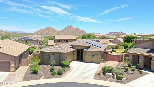 view of front of home featuring a garage, a mountain view, and solar panels