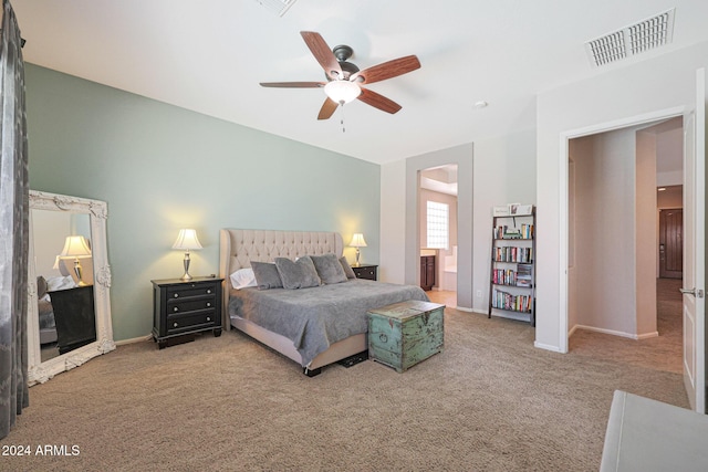 bedroom with ceiling fan, ensuite bathroom, and carpet floors