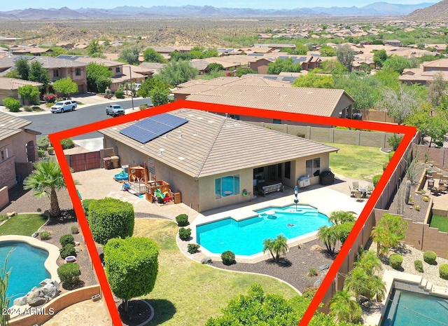 view of pool with a patio, a yard, and a mountain view