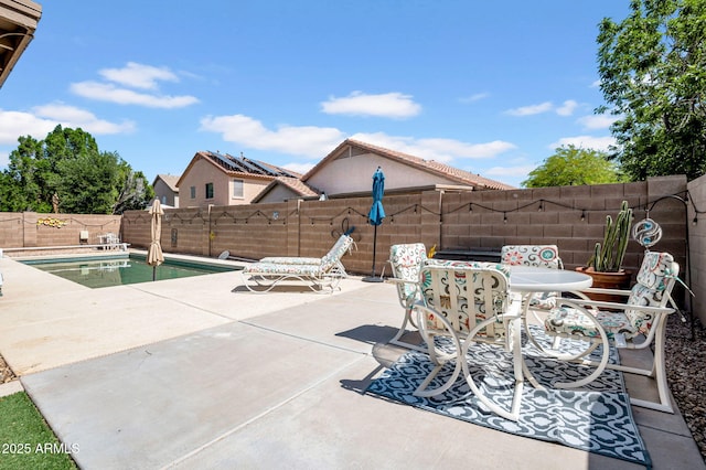 view of patio with a fenced in pool, outdoor dining area, and a fenced backyard