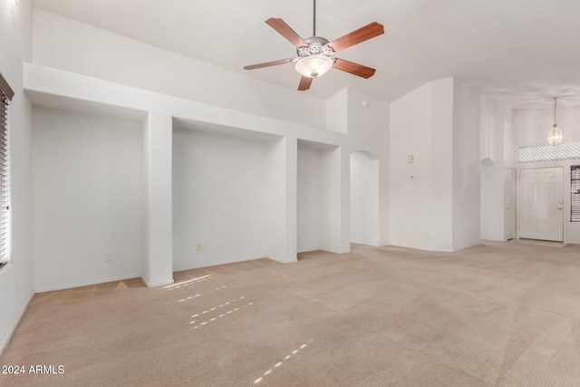 unfurnished living room with ceiling fan and light colored carpet