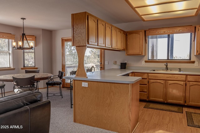 2806 Skyhawk Dr, Overgaard, AZ 85933 - kitchen with a sink, a peninsula, light countertops, pendant lighting, and a chandelier
