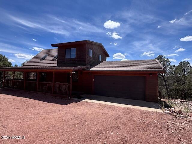 2806 Skyhawk Dr, Overgaard, AZ 85933 - chalet / cabin featuring a porch, driveway, and an attached garage