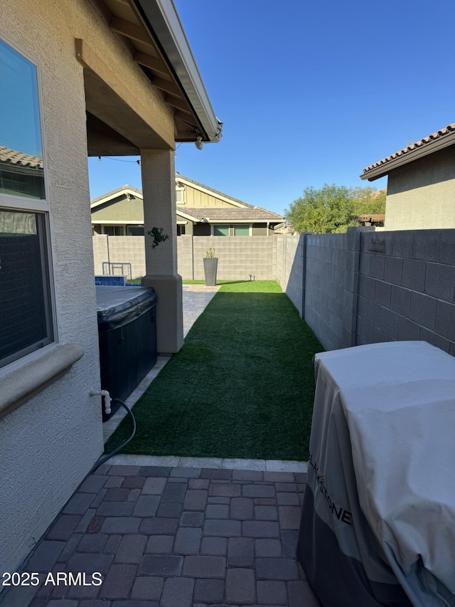 view of yard with a patio area and a hot tub