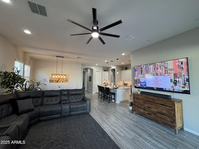 living room featuring hardwood / wood-style floors and ceiling fan