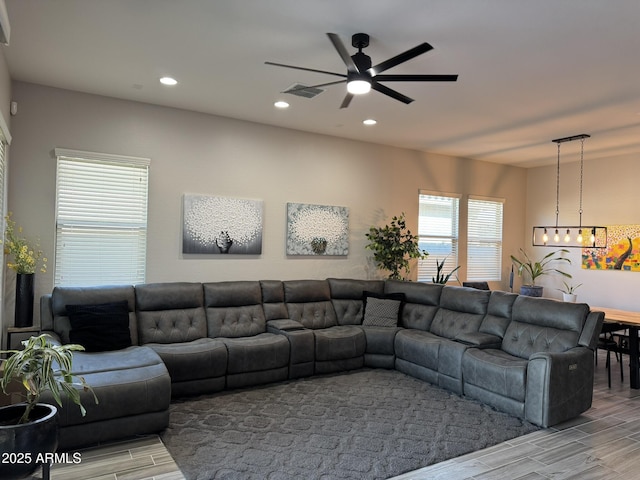 living room featuring ceiling fan with notable chandelier