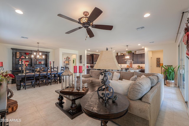 tiled living room featuring ceiling fan with notable chandelier