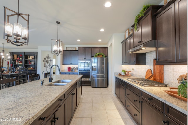 kitchen with stainless steel appliances, dark brown cabinets, sink, and pendant lighting