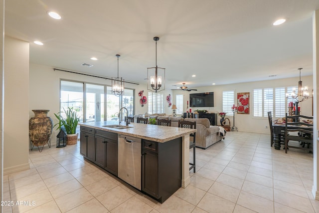 kitchen with sink, light tile patterned floors, dishwasher, a kitchen island with sink, and decorative light fixtures