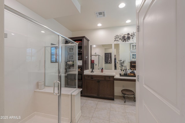 bathroom featuring tile patterned flooring, vanity, and walk in shower