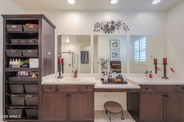 bathroom with walk in shower, vanity, and tile patterned flooring