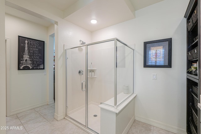 bathroom with an enclosed shower and tile patterned floors