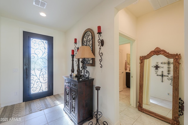 tiled entryway featuring vaulted ceiling