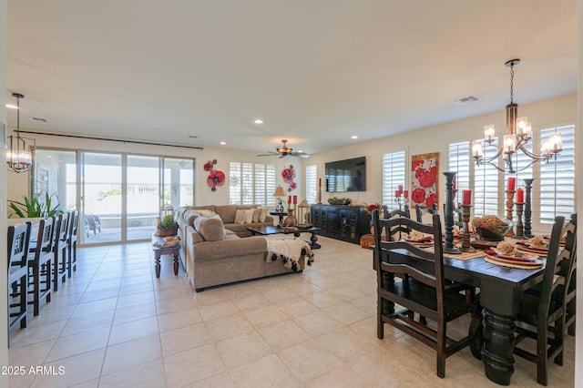 tiled dining room with ceiling fan with notable chandelier