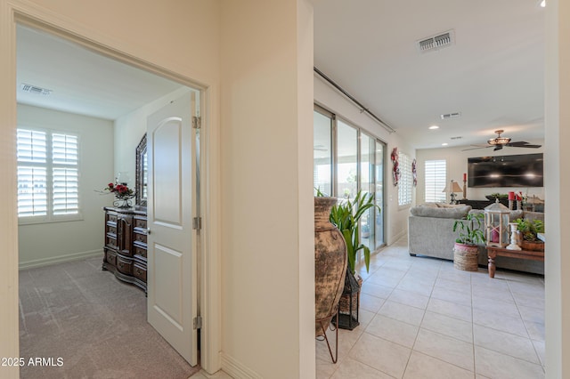 hall featuring a wealth of natural light and light tile patterned floors