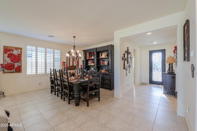 tiled dining area featuring a chandelier