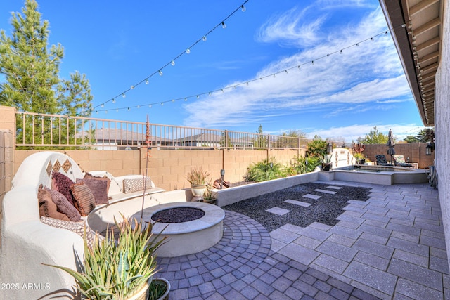 view of patio / terrace with a jacuzzi and a fire pit