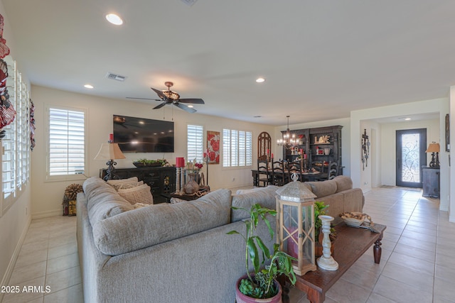 living room with light tile patterned flooring and ceiling fan with notable chandelier