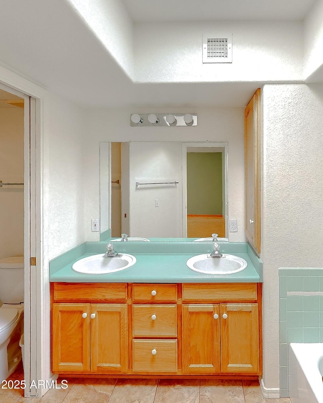 4484 Desert Springs Trl, Sierra Vista, AZ 85635 - full bathroom featuring toilet, double vanity, tile patterned flooring, and a bath