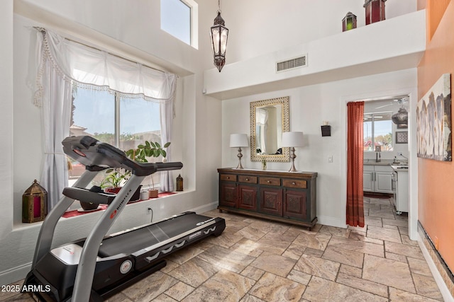 4331 E Redwood Ln, Phoenix, AZ 85048 - workout room with stone tile flooring, a high ceiling, and a ceiling fan