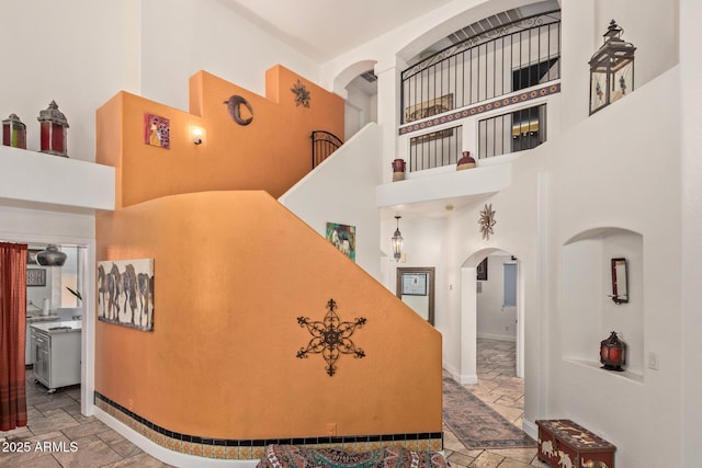 4331 E Redwood Ln, Phoenix, AZ 85048 - stairs featuring arched walkways, stone tile floors, and a towering ceiling