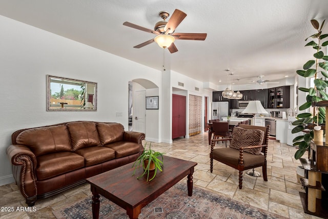 4331 E Redwood Ln, Phoenix, AZ 85048 - living area featuring a ceiling fan, stone tile floors, and arched walkways